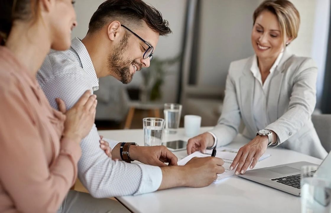 An agent and clients signing closing documents