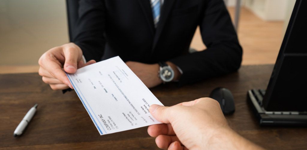 A commission check being handed over